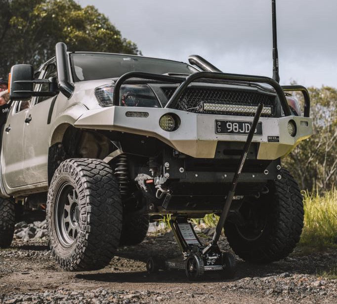 grey ute being lifted by a titan terrain rugged floor jack