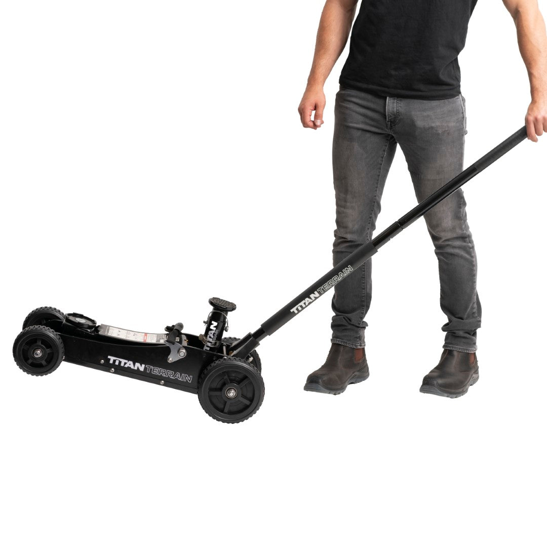 Man tilting Titan Terrain rugged off-road floor jack onto back wheels