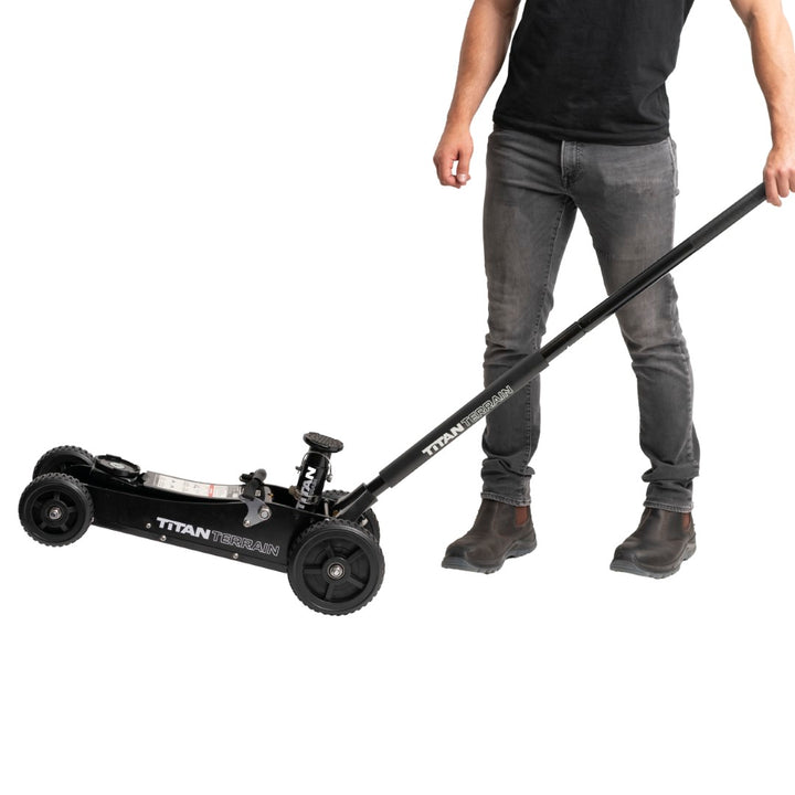 Man tilting Titan Terrain rugged off-road floor jack onto back wheels