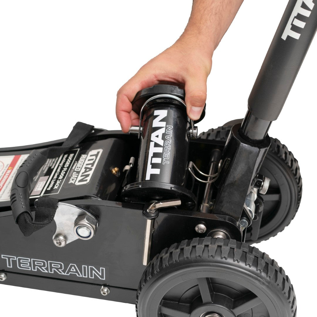 Hand removing jack extension from Titan Terrain rugged off-road floor jack