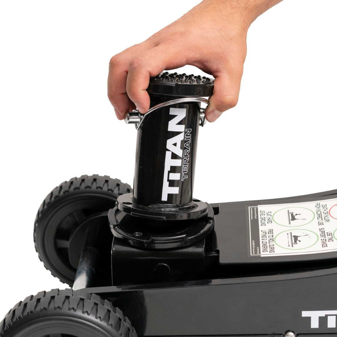Hand placing jack extension on Titan Terrain rugged off-road floor jack base plate