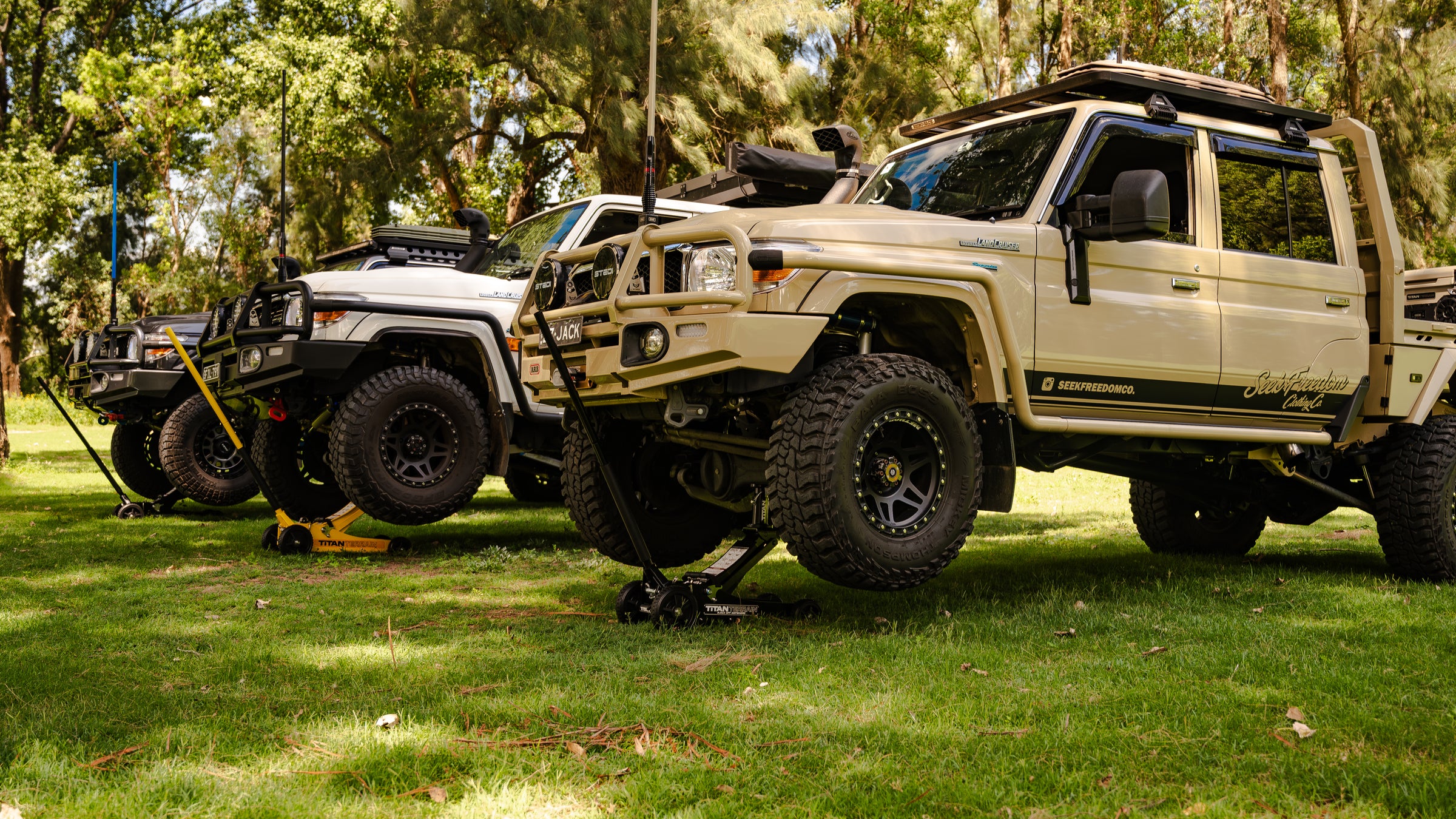 Three modified utes being jacked up three titan terrain rugged floor jacks