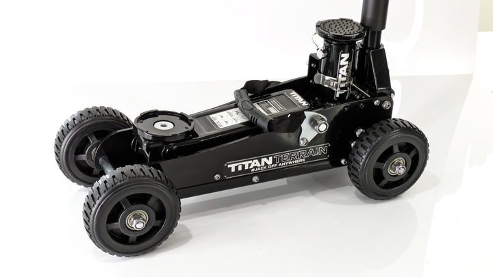 A black rugged floor jack with a hydraulic pump and four large wheels, designed for off-road conditions.