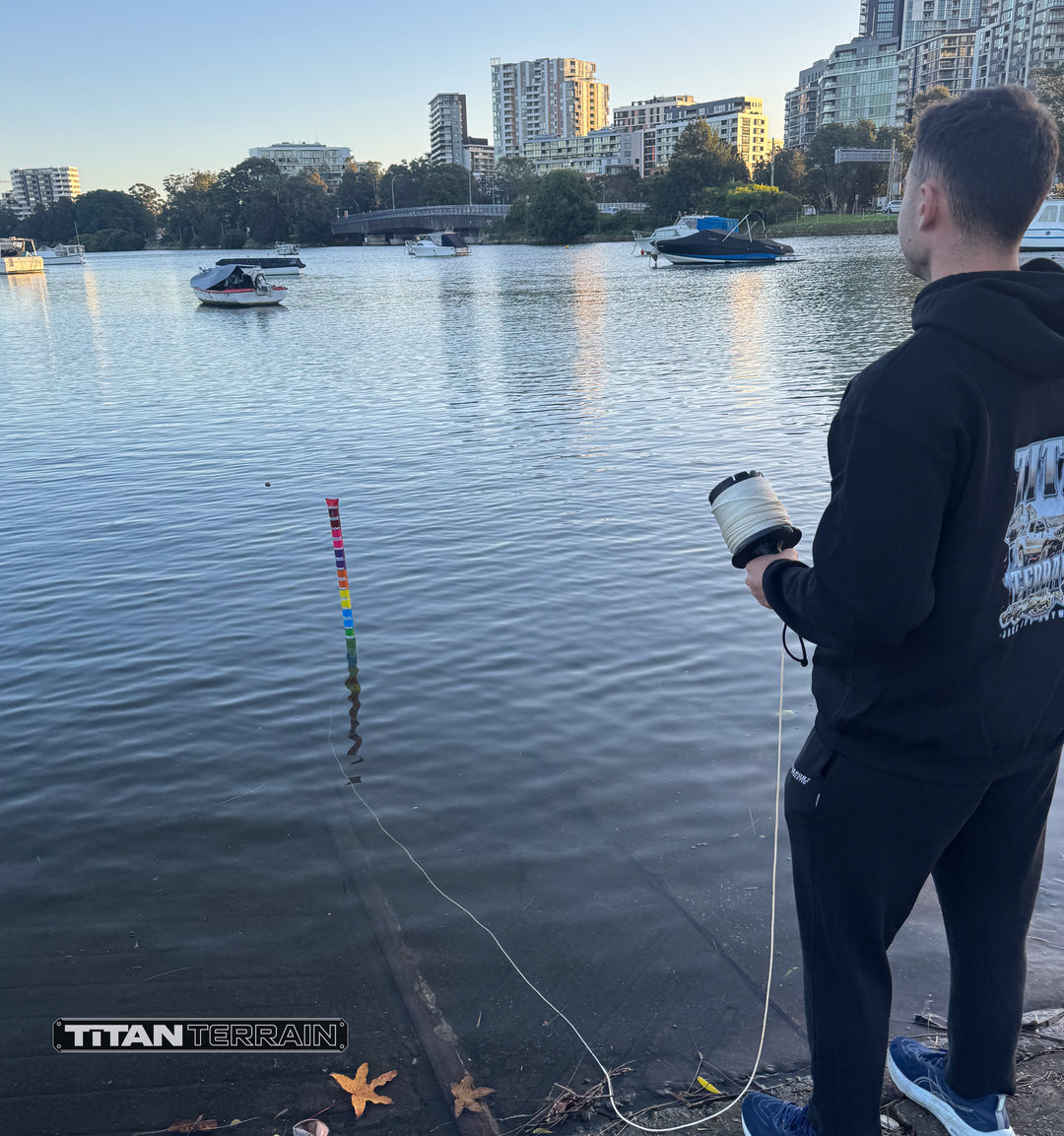 Person demonstrating titan terrain depth gauge on lake with boats